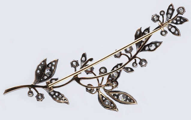 Брошь из желтого и белого металла, общим весом 18,27 грамма, содержит природные вставки из бриллиантов